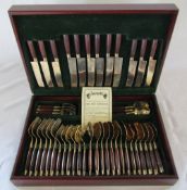 Cased gold plated canteen of cutlery with wooden handles