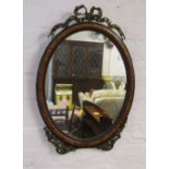 Ornate oval mirror with gilded ribbon embelishments