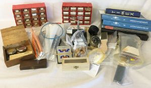 2 small cabinets containing watch & clock parts including crystals,