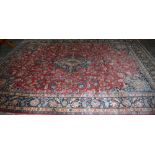 Large Persian red ground Mashad carpet with traditional central medallion design