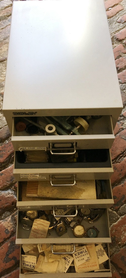 Small Bisley cabinet containing watch tools & parts mainly Timex