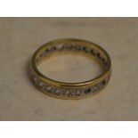 Yellow metal (possibly 18ct - hallmarks unreadable) eternity ring with some stones missing,