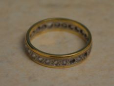 Yellow metal (possibly 18ct - hallmarks unreadable) eternity ring with some stones missing,