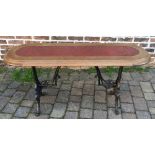 Ornate cast iron pub table with a wooden oval top L 136cm W 46cm