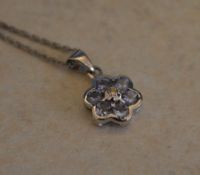 9ct white gold necklace with a 9ct white gold flower pendant set with a small central diamond and