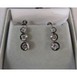 Pair of platinum triple graduated diamond earrings (total carat weight 0.