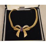 9ct gold necklace with a diamond and amethyst pendant shaped as an ornate bow,