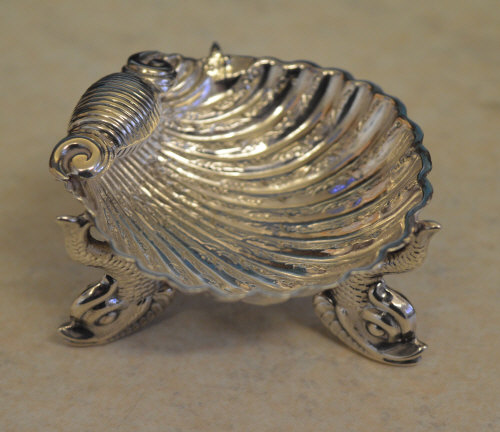 Small ornately decorated shell dish raised on three legs, each shaped as fish, Birmingham 1881,