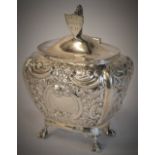 An ornate Edwardian silver tea caddy decorated with flowers and leaves,