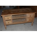 A waxed pine low side table, fitted four drawers and central recess, on turned supports, 44" long