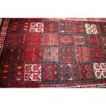 A Persian garden rug with geometric designs in shades of red, brown, orange and natural, 98" x 65"