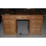 A waxed pine double pedestal desk, fitted nine drawers, on block base, top 58" x 28"