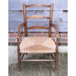 An ash and fruitwood ladder back elbow chair with rush envelope seat, two rush envelope seat bedroom