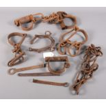 A quantity of various 19th century cast iron shackles, handcuffs, etc