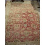 An Indian rug decorated flowers on a red ground with a floral border, 128" x 95" approx