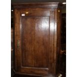 A late Georgian oak corner hanging cupboard enclosed panel door, 26" wide