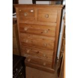 A pine chest of two short and four long drawers with knob handles, 32" wide, and an African carved