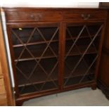 A mahogany bookcase, fitted two drawers over two lattice glazed doors, on bracket feet, 48" wide