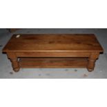 A waxed pine two-tier coffee table, on turned supports, 48" long