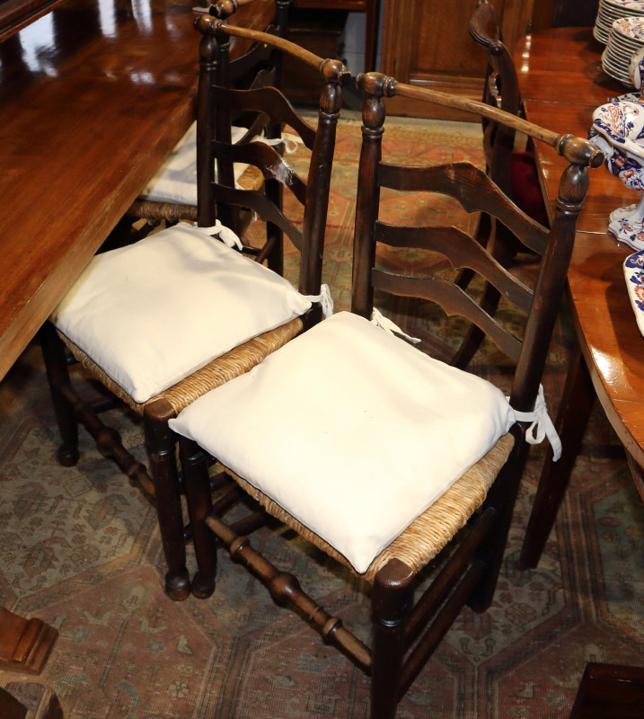 A pair of late 19th century oak ladder back chairs with drop-in rush envelope seats, on turned and