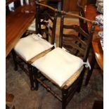 A pair of late 19th century oak ladder back chairs with drop-in rush envelope seats, on turned and