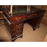 A stained as mahogany double pedestal desk, fitted nine drawers with tooled and gilt leather top,
