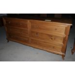 A waxed pine chest of six long drawers, on shaped supports, 72" wide