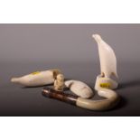 A collection of various sperm whale scrimshaw carvings a carved ivory cane handle with silver collar