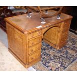 A late Victorian figured ash double pedestal desk with tooled leather lined top, fitted eight