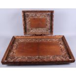 Two Chinese hardwood trays, carved with roaming dragons and Buddhist symbols