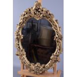 A convex wall mirror in circular oak frame, plate 8 1/2" dia, an oval scrollwork framed wall mirror,