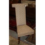 A Victorian walnut framed prie-dieu, upholstered in a beige patterned fabric, on turned and castored