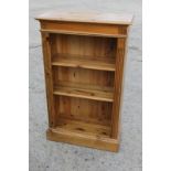 A pine narrow open bookcase, on block base