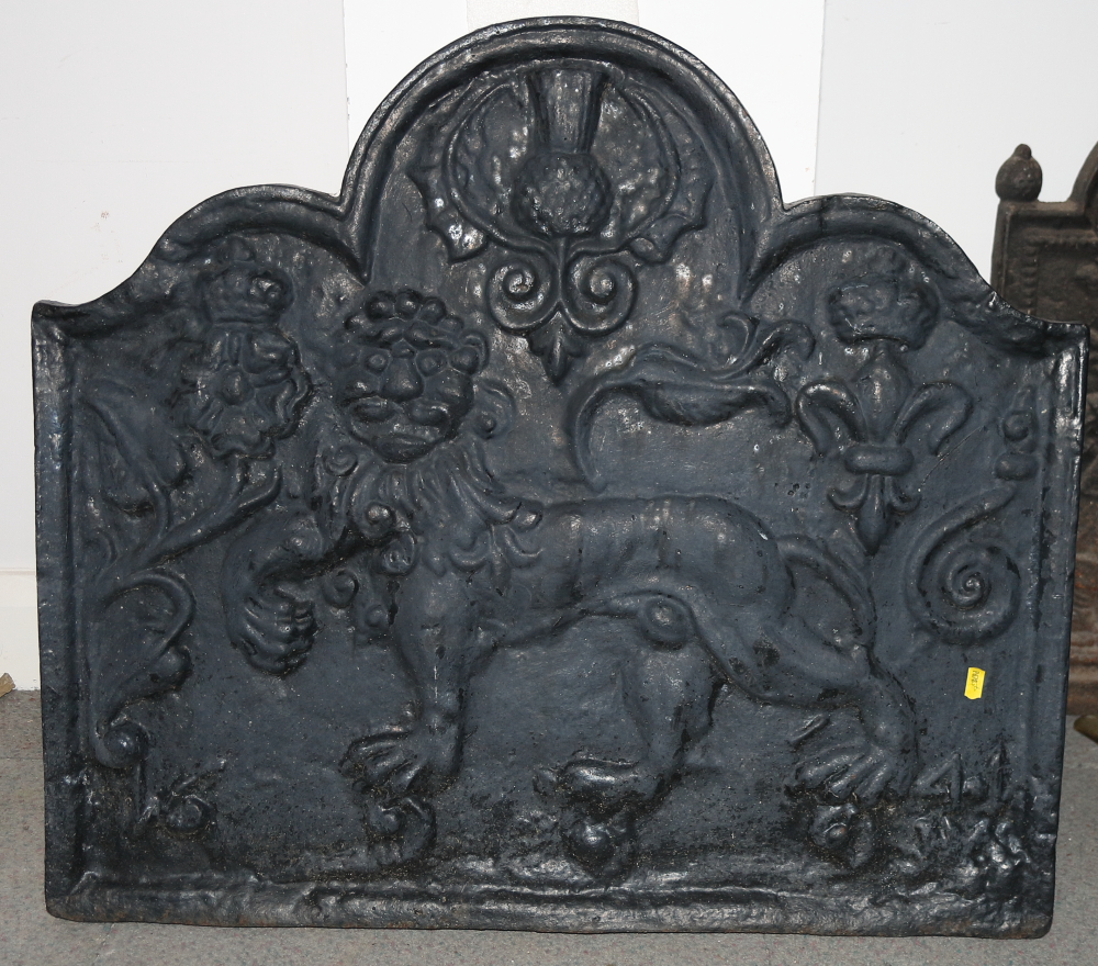 A cast iron fireback with lion and scroll design, 31" wide