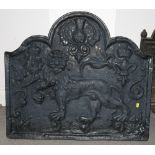 A cast iron fireback with lion and scroll design, 31" wide