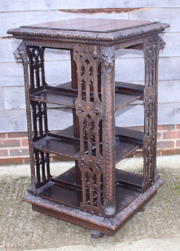 A late Victorian carved pierced oak revolving bookcase with lion mask decoration, 26" square