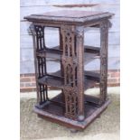 A late Victorian carved pierced oak revolving bookcase with lion mask decoration, 26" square