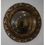 A 19th century design gilt circular wall mirror, carved with acanthus leaves, and an early 20th
