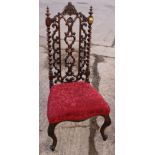 A 19th century rosewood pierced splat back low seat nursing chair, on cabriole supports, and an Arts