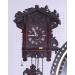A Black Forrest style carved wooden cased cuckoo clock by Camerer Cuss & Co, London