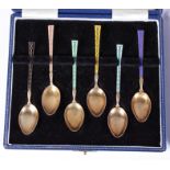 A set of six silver gilt coffee spoons with enamelled handles, in fitted case