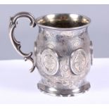 A Victorian silver christening mug with 'S' scroll handle and engraved floral decoration and scallop