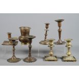 Seven 19th century and earlier brass candlesticks together with a small Indian brass spittoon
