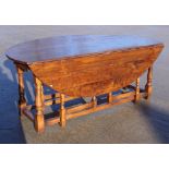 An oak "wake" table with wavy top, fitted single drawer, on double gate leg supports, 78" long