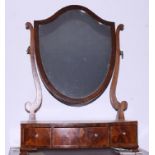 A late Georgian mahogany shield-shaped toilet mirror, on bowfront plateau base, fitted three