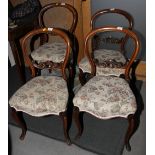 A set of four 19th century carved walnut loopback standard dining chairs with stuffed over seats, on