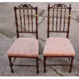 A pair of 19th century rosewood spindle back bedroom chairs with padded seats, on turned and