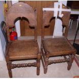 A pair of oak hall chairs with arch top backs and panel seats, on stretchered supports