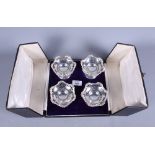 A set of four cased silver pierced openwork bonbon stands, on weighted bases, 3" high