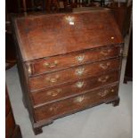 A late 18th century/early 19th century oak fall front bureau, fitted four drawers with swing brass